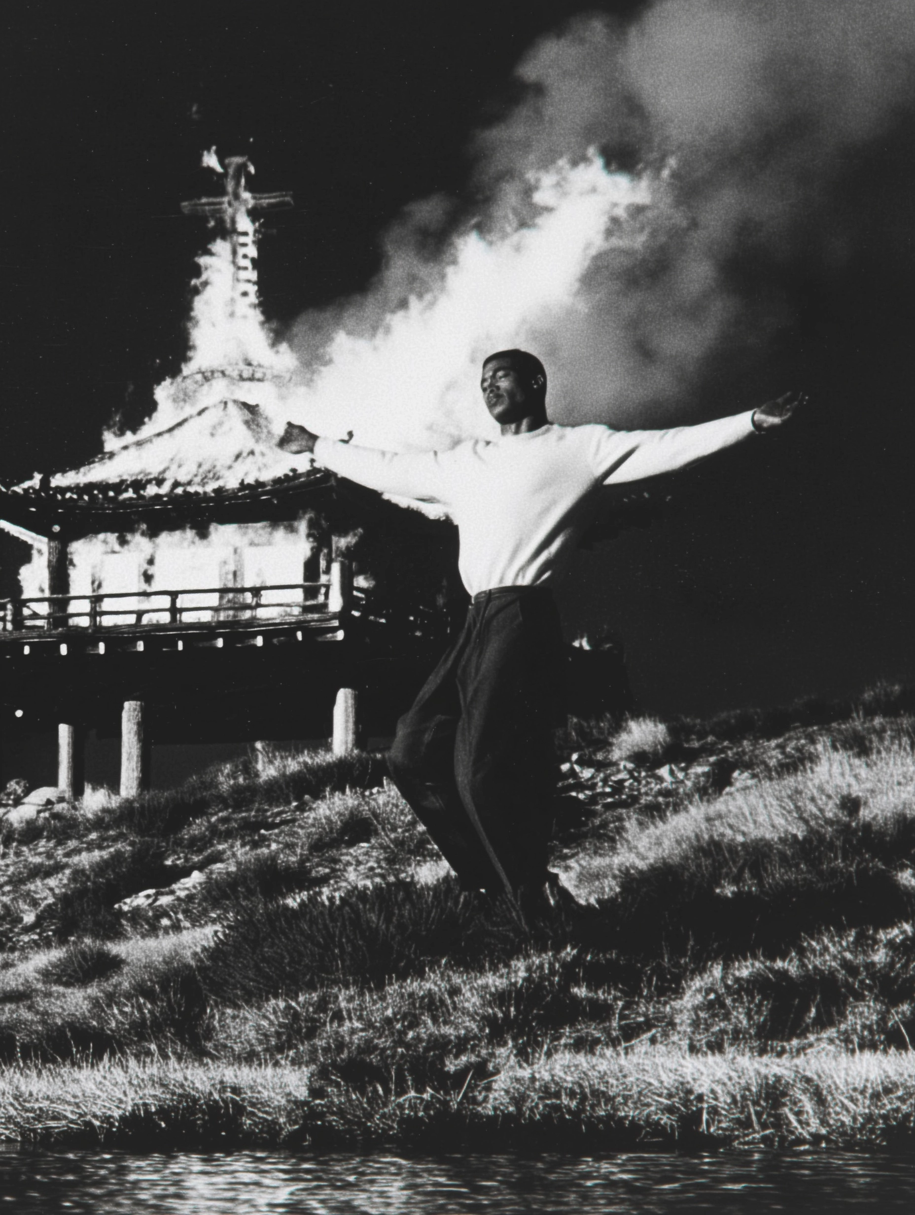 A man on a hillside with his arms in the shape of a cross
