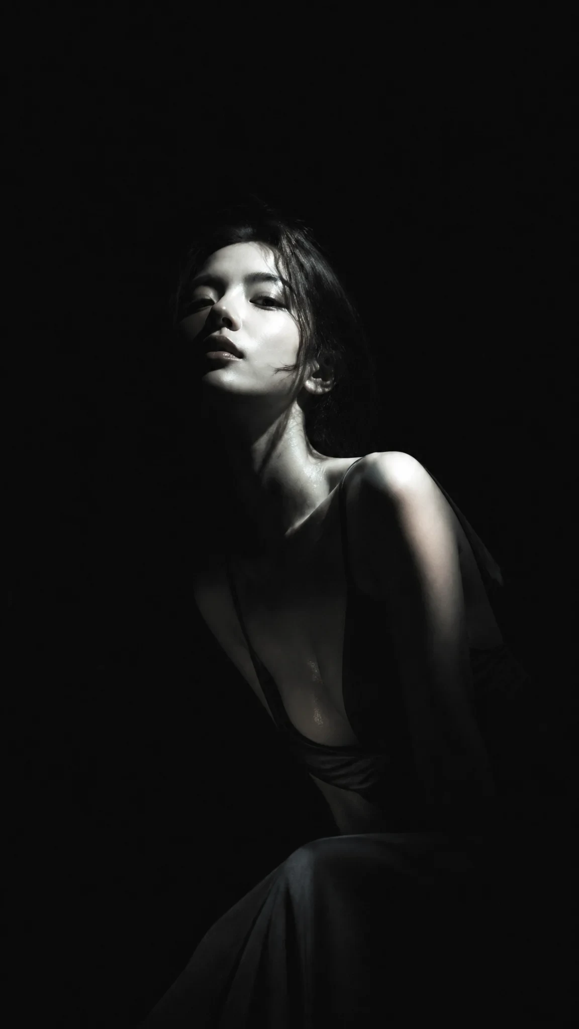 It's a pretty Korean star in a dark, low-coloured dress, with cold eyes, beautiful faces, pure black backgroun