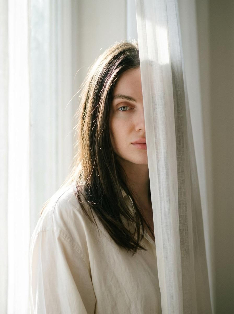 Woman Peeking Through Sheer Curtain
