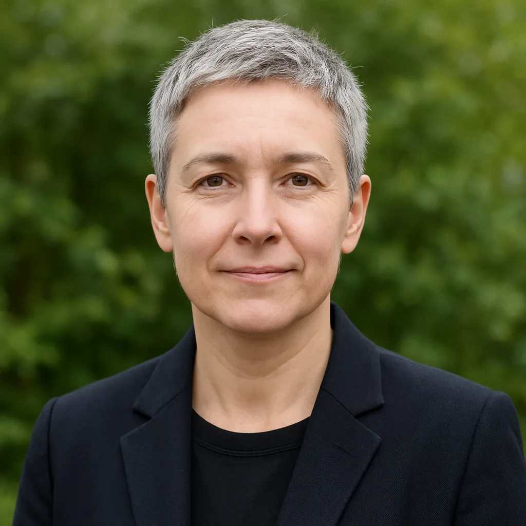 Person with Short Gray Hair Wearing a Dark Blazer Stands