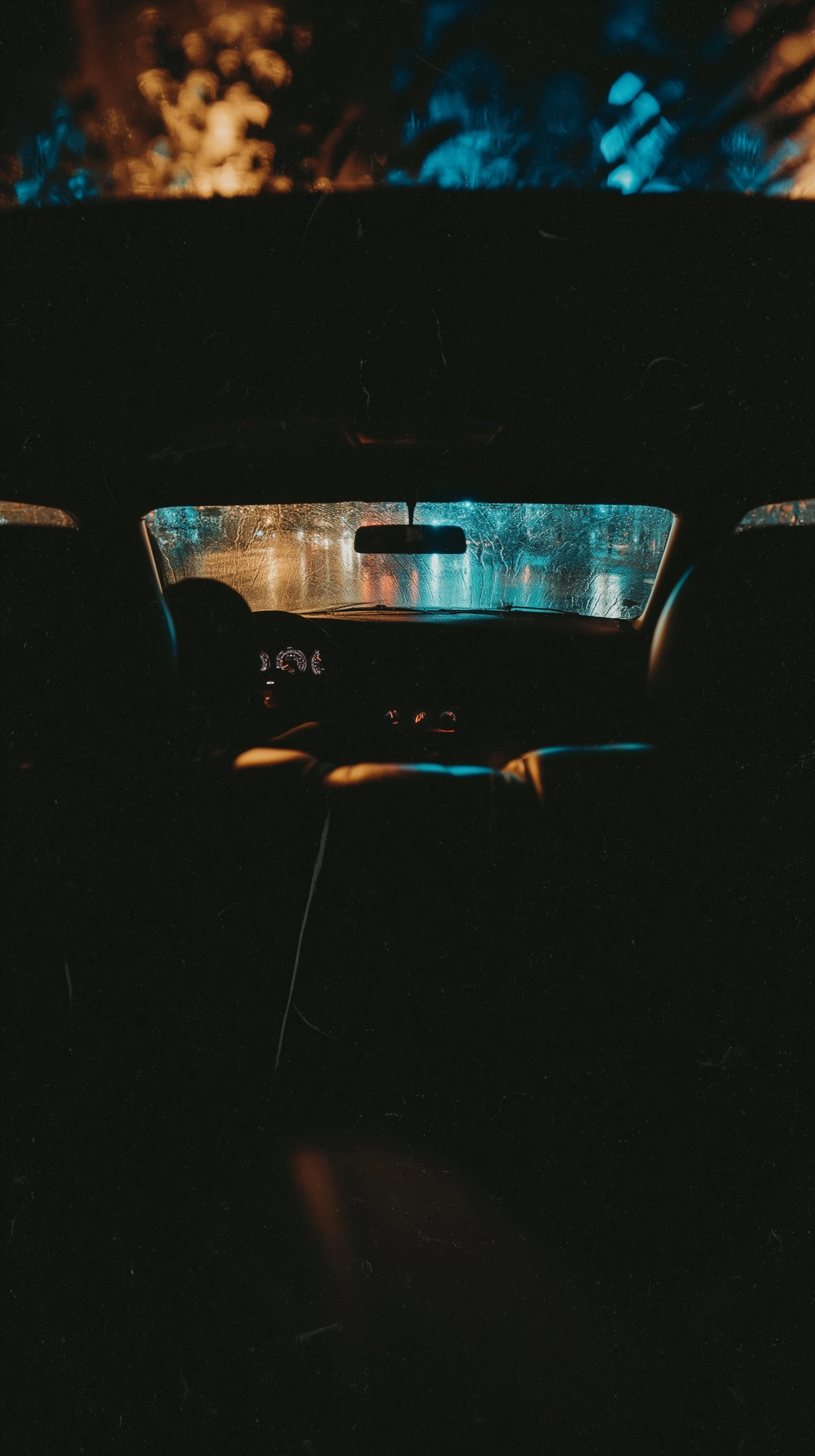 A raw, cinematic POV shot from the dead center of the back seat of a car
