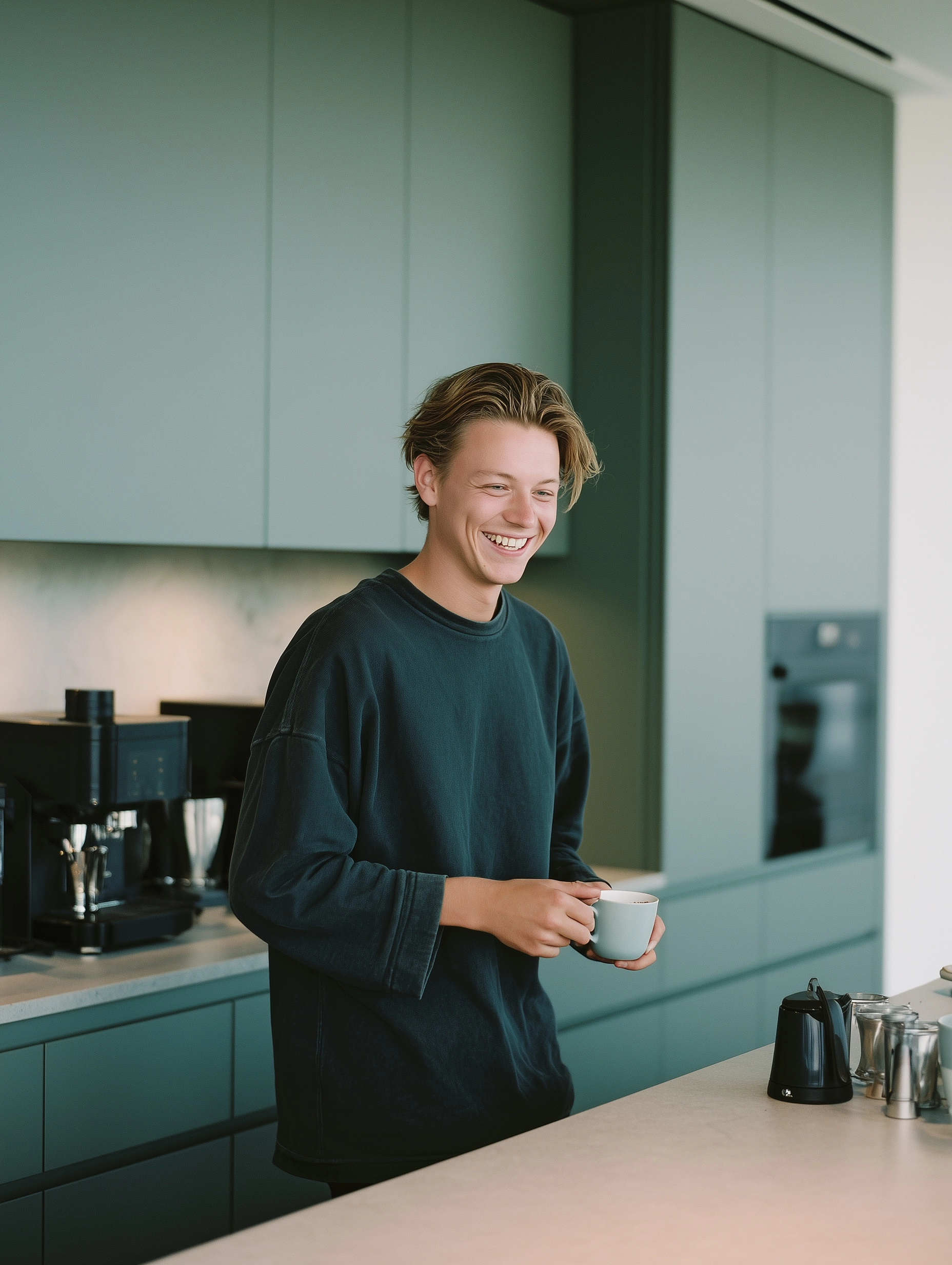 Cinematic, lifestyle photography smiling young man making coffee in a sleek modern kitchen medium sh