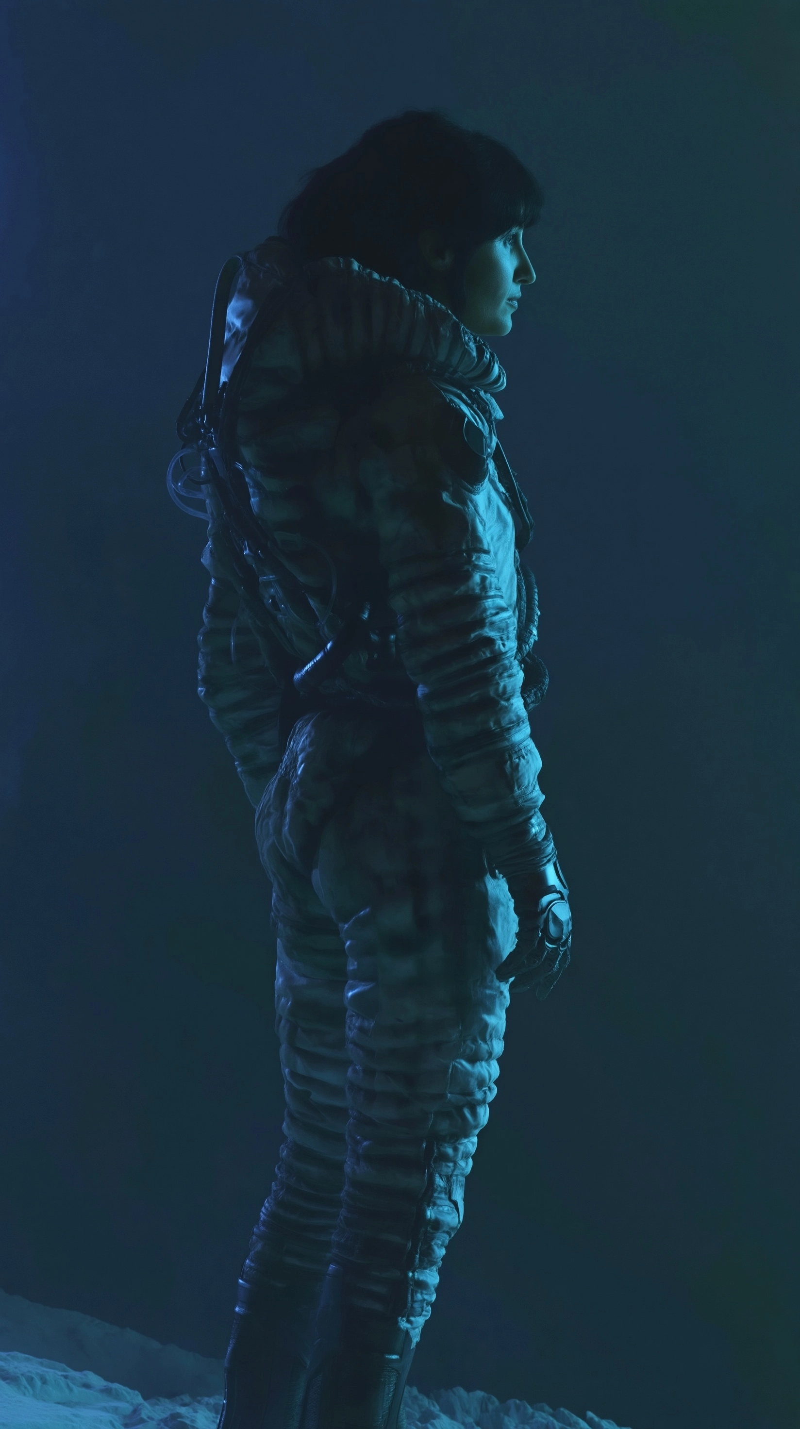 Full body shot of a lone female explorer, standing and turned slightly away from camera