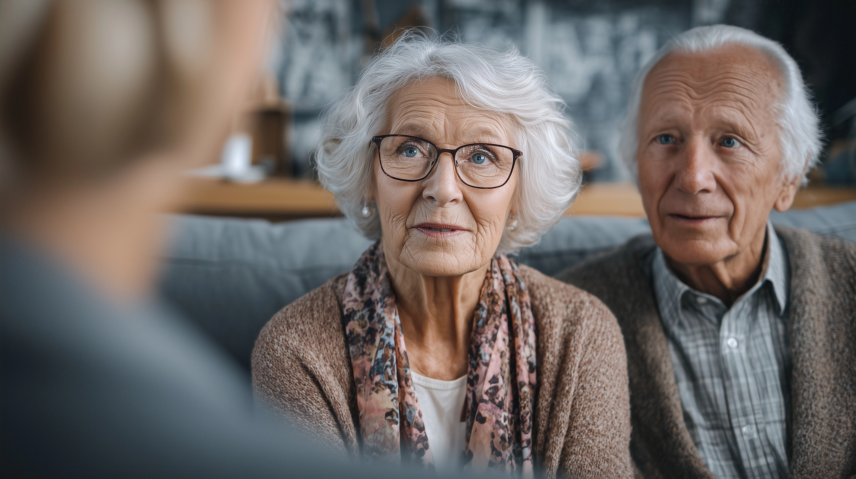 Very old couple receiving hearing aid consultation from a consultant