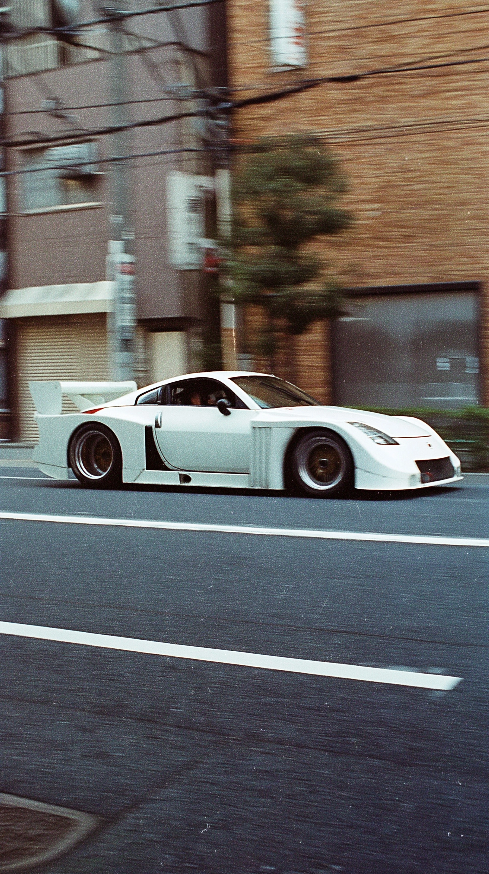 Panning shot of a Nissan 350Z Turbo from Group 5 race cars with a massive widebody and aero