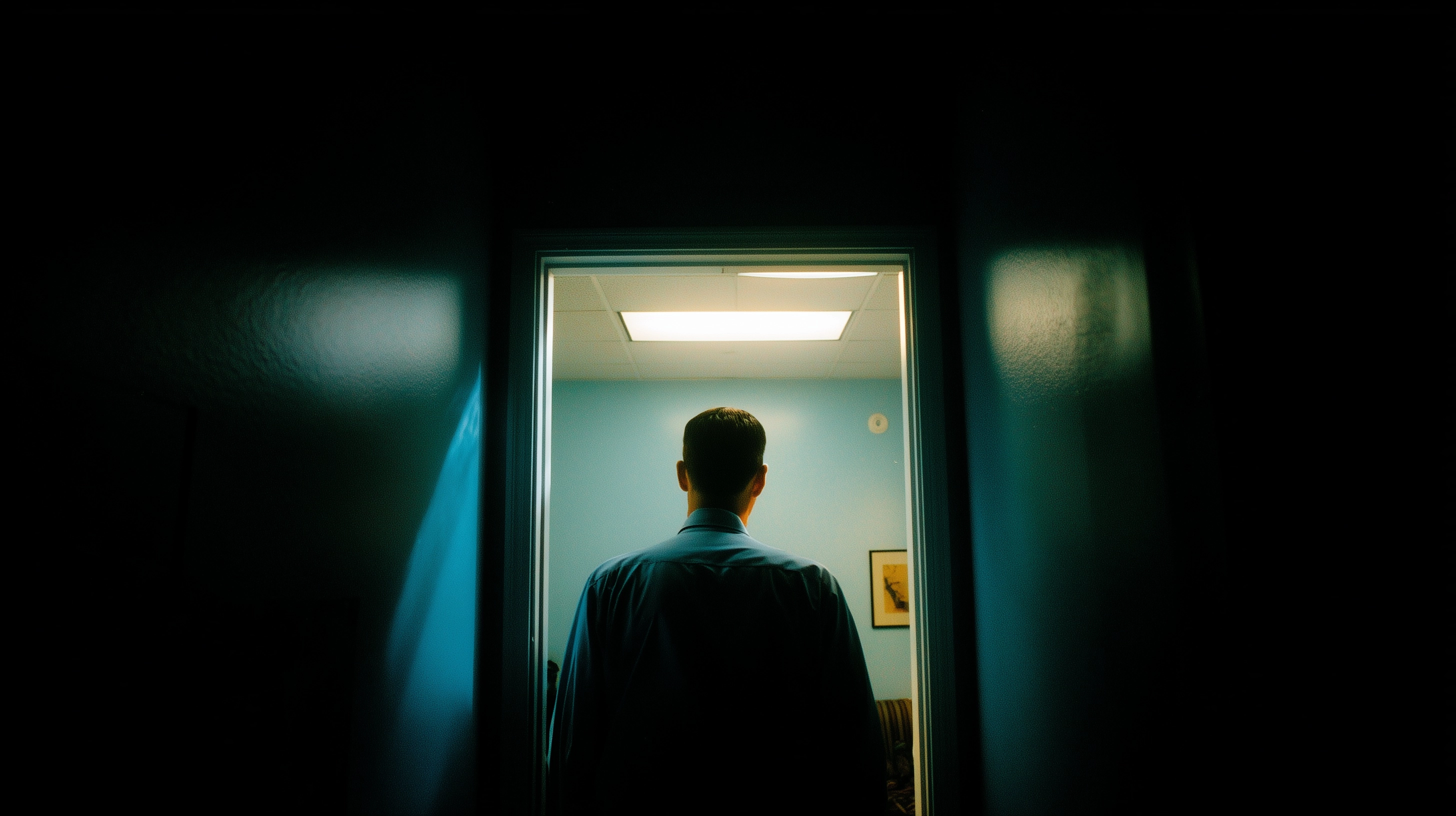 Back of a man's head walking out of a doctor's office, wide angle, hard flash