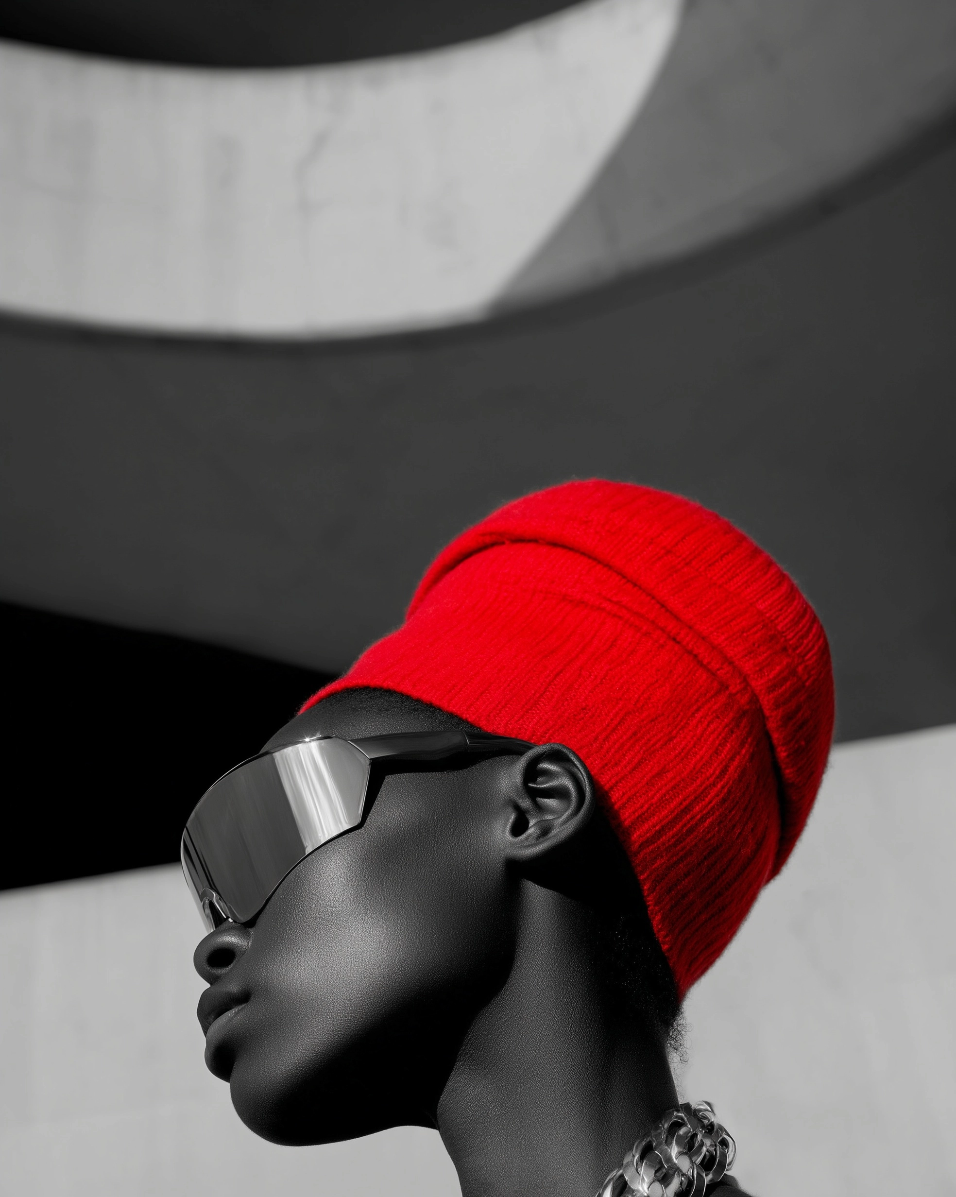Artistic profile closeup, black-skinned model in bold mirrored wrap-around sunglasses