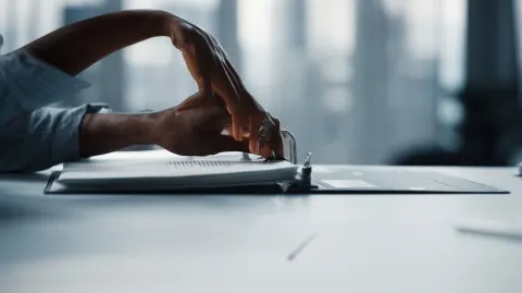 Stock style, hyper realistic, high quality photo, close-up of woman’s hands assembling a report bind