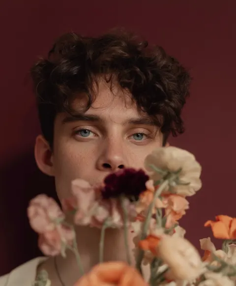 Artistic portrait of the elegant young man, with brown hair, blue eyes, freckles