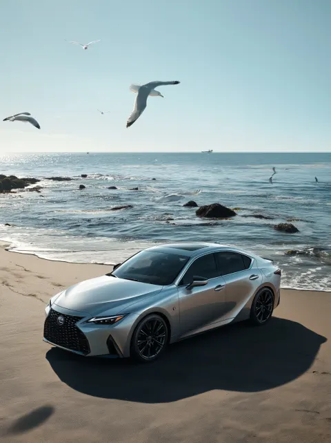 A silver-colored lexus electric car is parked on the beach