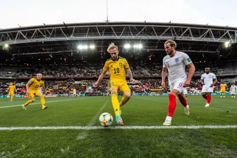 Action shot of men playing football (soccer) in a big national stadium, action shot. Colorful