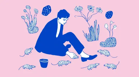 A man in a suit feeding rats on the street