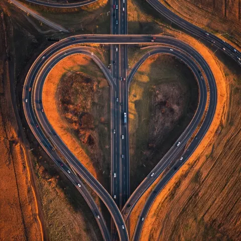 Top down aerial cinematic shot of a highway interchange forming a clearly recognizable strawberry sh