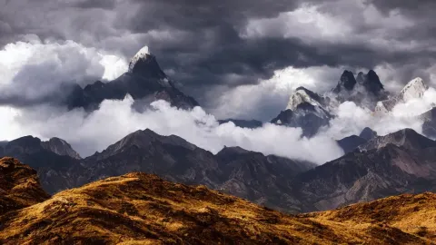 Cinematic Landscape Photograph of a Mountains Peak in the Clouds