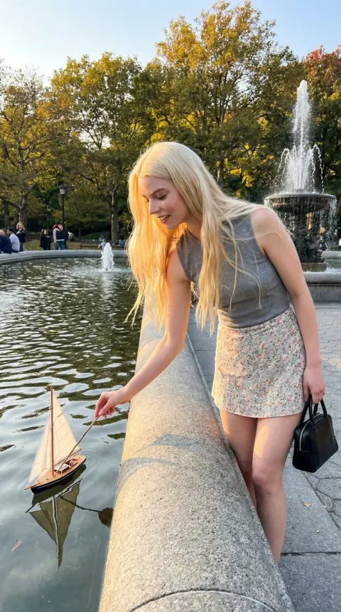 Girl Playing with Sailboat by Fountain