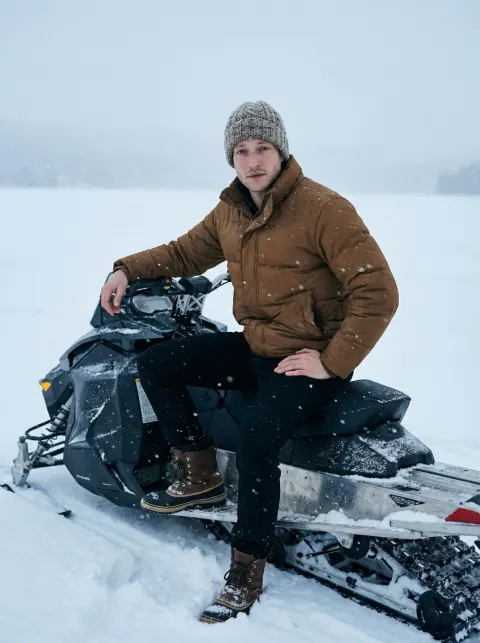 Man on Snowmobile in Winter Snowfall