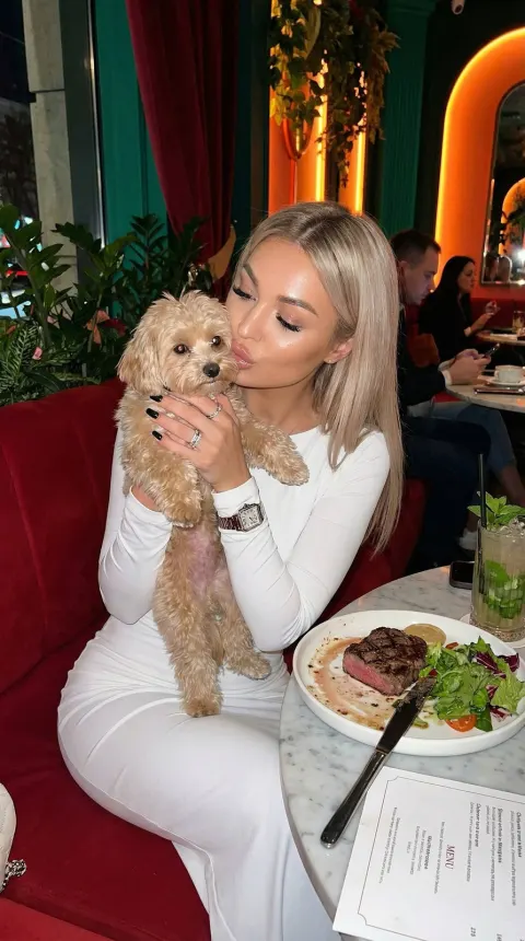 Stylish Girl Kissing Dog at Cafe