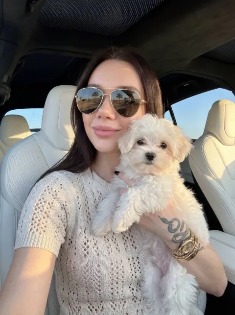 Glamorous Woman with Fluffy Dog in Luxury Car