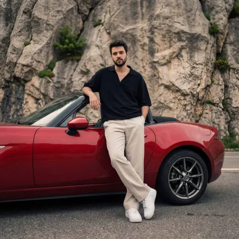 Stylish Man Leaning On Red Convertible