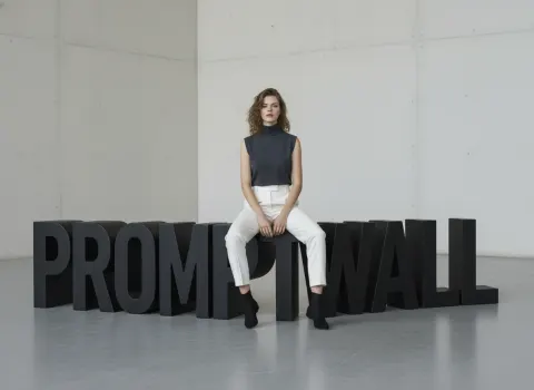 Beauty sitting on letters sculpture