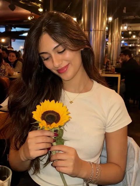 Smiling Woman Holding Flower in Warm Light