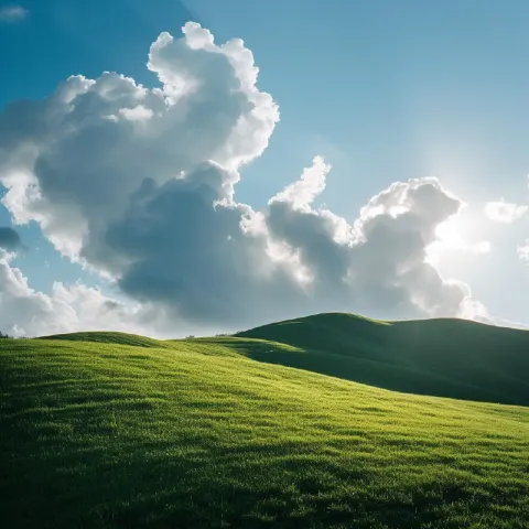 Clouds Resting on a Sunlit Green Hillside Photo