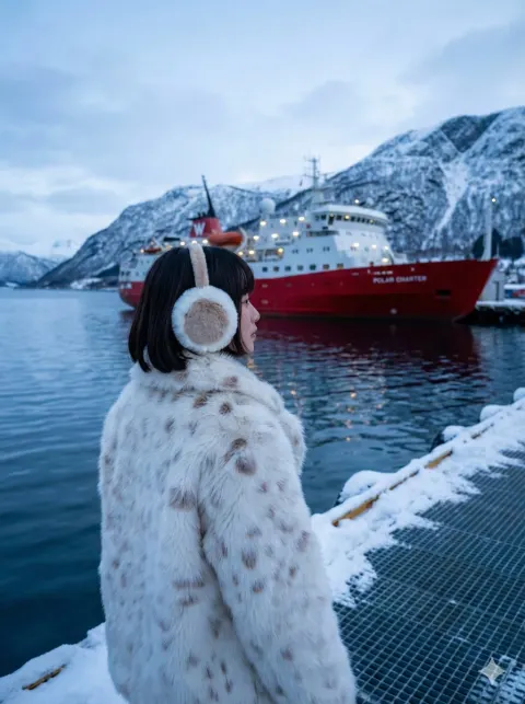 Woman Gazing at Red Ship in Snowy Harbor