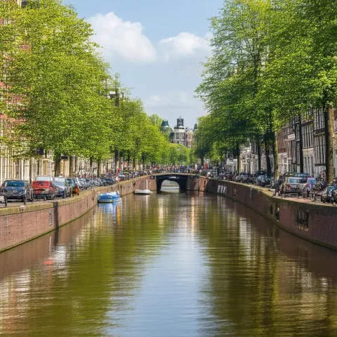 Amsterdam Canal Reflections in Vibrant Street Life