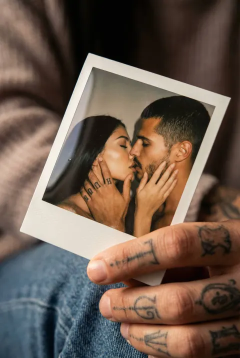 Tattooed Hand Holds Kiss Polaroid