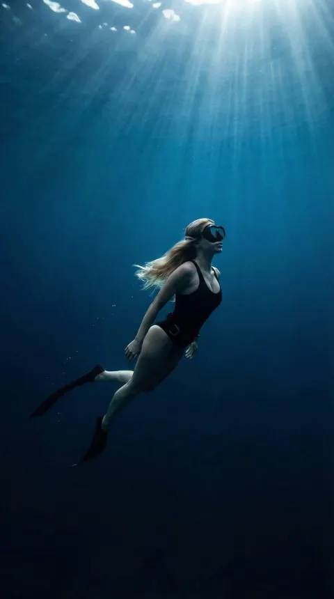 Girl Swimming Underwater In Ocean