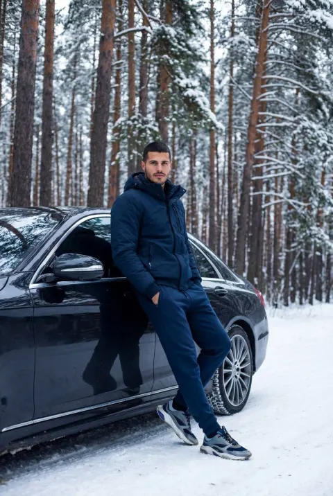 Confident Man by Luxury Car in Snow