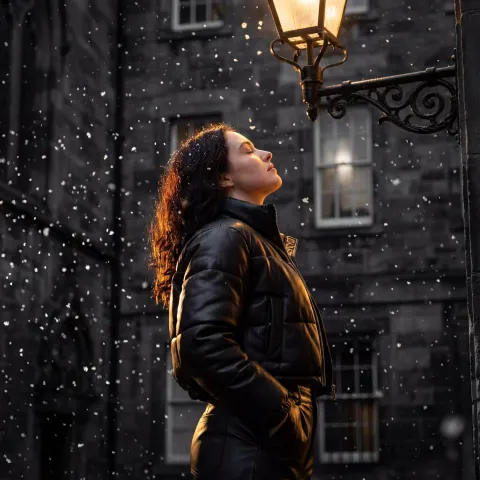 Snowy Night Portrait Under Golden Lamp