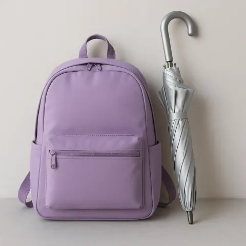 Silver Umbrella Positioned Beside a Lavender Backpack
