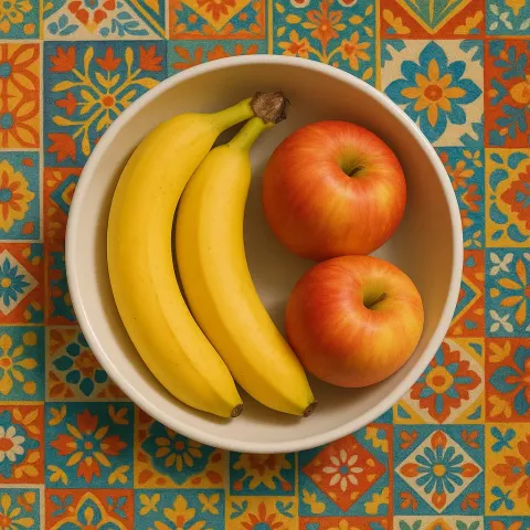 White Bowl Containing Two Ripe Bananas and Two Apples Sits