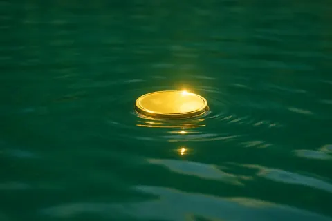 Slender Gold Coin Shimmers Remarkably as It Floats
