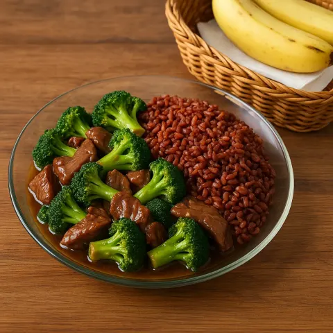 Glass Plate with Broccoli and Beef Stir-fry Alongside Red Rice