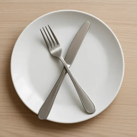 White Plate with a Knife and Fork Arranged So