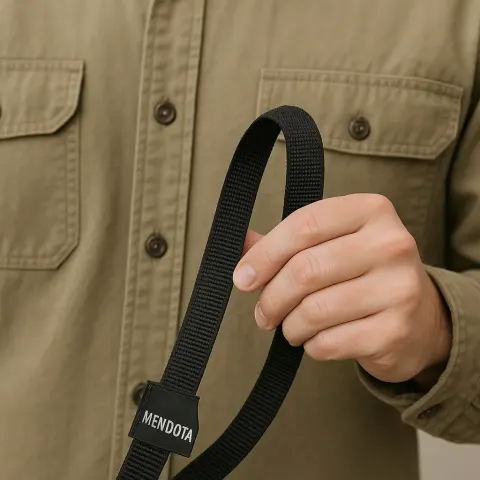 Person Wearing a Khaki Shirt Holds a Black Strap