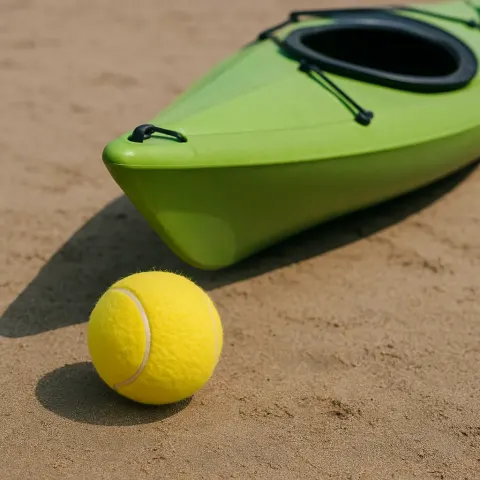 Green Kayak with a Yellow Sports Ball Positioned Nearby