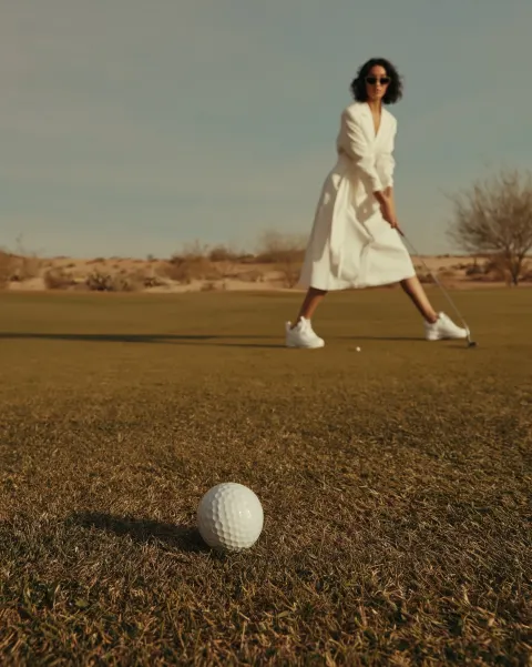 Editorial fashion lifestyle photography, playful golf scene on a sunny desert golf course