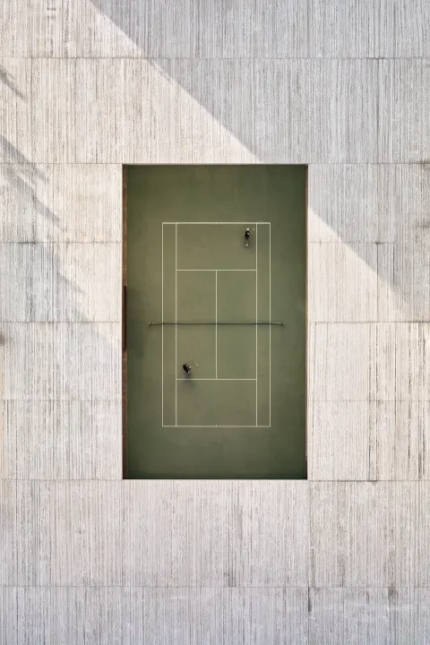 Strict top-down orthogonal architectural view of a luxury modern tennis court centered in the frame