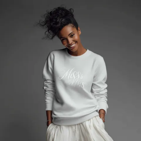 Create a realistic bride wearing a bridal sweatshirt that says Miss to Mrs.; she is happy