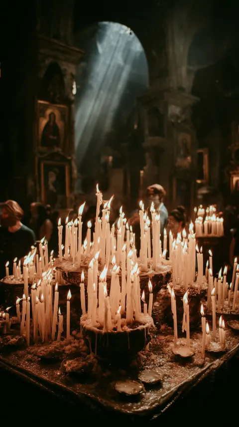 Cinematic close-up of multiple burning candles inside a catholic church