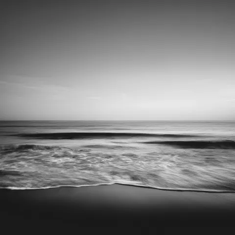 A black-and-white minimalist photograph of the ocean
