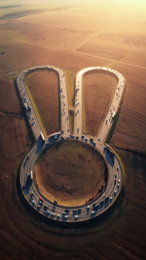 Top down aerial cinematic shot of a highway interchange forming a clearly recognizable bunny head wi