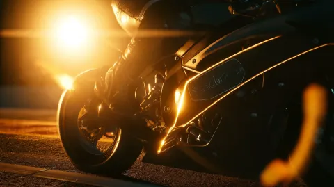 Cinematic close-up shot of a racing motorcycle parked on a night track starting line. The rider in a