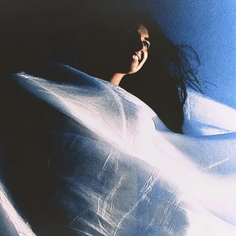 A beautiful woman wearing a white silk dress, standing in the wind and smiling gently. Cyberpunk pho