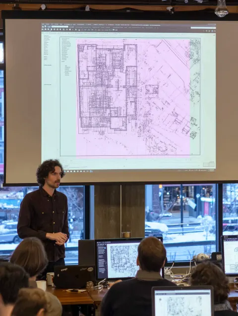 A confident professional presenting to a small attentive group in a bright minimalist boardroom