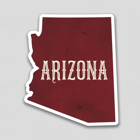 A sticker of the state shape of arizona with western victorian text "arizona" in white on a maroon-c