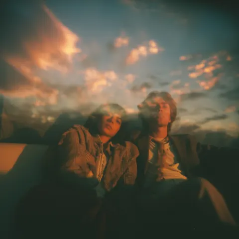 90's photogaphy sunset couple surreal of couple on a couch watching a surreal sky. Grain